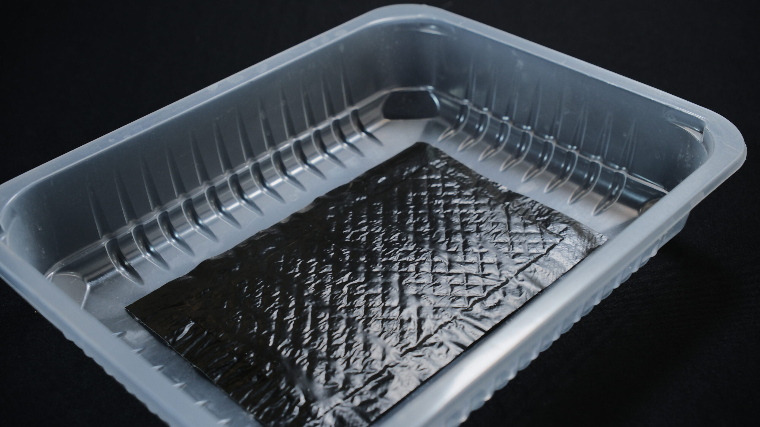 Absorbent pad placed in a clear food packaging tray
